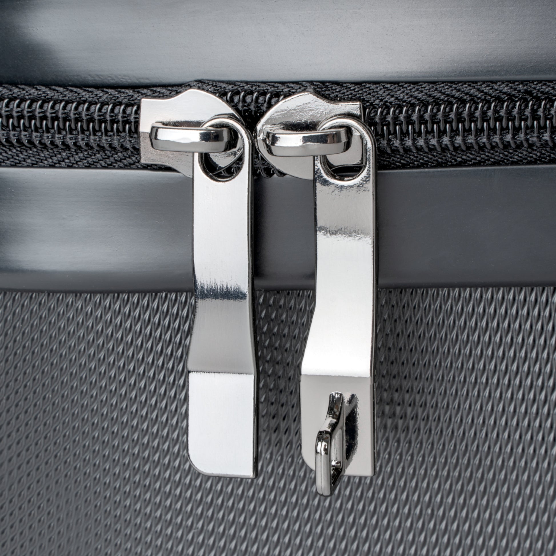 detail of stainless steel zipper tabs on suitcase