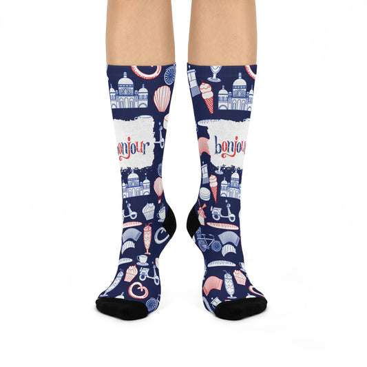 A pair of blue and navy colored socks with a design featuring French motifs such as the Eiffel Tower, a chocolate dessert, and other cultural elements.